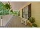 Spacious covered porch with swing, rocking chair, and green foliage for a tranquil outdoor experience at 4950 Creel Rd, Fairburn, GA 30213