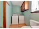 Convenient laundry room features washer, dryer, overhead storage, and a toilet at 4950 Creel Rd, Fairburn, GA 30213