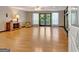Open living room with hardwood floors, stone fireplace, and double doors leading to the outside at 4950 Creel Rd, Fairburn, GA 30213