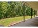 Covered patio with black pillars, showcasing the lush backyard and peaceful setting at 4950 Creel Rd, Fairburn, GA 30213