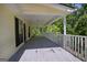 View of the large covered porch, with white railings, and a view to the wooded back yard at 4950 Creel Rd, Fairburn, GA 30213