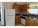 Bright kitchen with wooden cabinets, white appliances, and tiled floor at 3505 Saddle Creek Ln, Ellenwood, GA 30294
