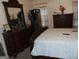 A traditionally styled bedroom featuring dark wood furniture, including a dresser, wardrobe and headboard at 4032 Ward Lake Trl, Ellenwood, GA 30294