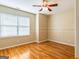 Bright bedroom with hardwood floors, a ceiling fan, and a large window, creating a cozy and inviting atmosphere at 2810 Promenade Pl, Buford, GA 30519