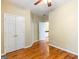 Empty bedroom featuring hardwood floors, a ceiling fan, and double doors leading to a closet at 2810 Promenade Pl, Buford, GA 30519