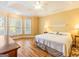 Spacious bedroom featuring a tray ceiling, hardwood floors, and plenty of natural light from the many windows at 2810 Promenade Pl, Buford, GA 30519