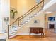 Inviting entryway with wooden staircase, decorative accents, and hardwood flooring throughout at 2810 Promenade Pl, Buford, GA 30519