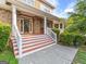 Inviting front porch with stone accents, white columns, and decorative front door at 2810 Promenade Pl, Buford, GA 30519