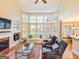 Bright living room boasts a fireplace, comfortable seating, large windows, and hardwood floors at 2810 Promenade Pl, Buford, GA 30519