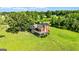 Aerial view of a charming house surrounded by a large grassy field and mature trees at 68 Riveree Rd, Brooks, GA 30205