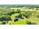 Expansive aerial view of a red farmhouse with surrounding green pastures, pond, and lush trees at 68 Riveree Rd, Brooks, GA 30205