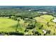 Scenic aerial view of the property with lush forests, open fields, and a peaceful lake at 68 Riveree Rd, Brooks, GA 30205