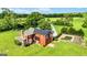 The back exterior boasts an in-ground pool, lush yard, and red facade in a private setting at 68 Riveree Rd, Brooks, GA 30205