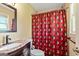 Bathroom with marble countertops, wood cabinets and decorative shower curtain at 68 Riveree Rd, Brooks, GA 30205