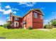 Exterior view of a two-story red home with a chimney and a well-maintained lawn at 68 Riveree Rd, Brooks, GA 30205