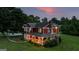 Beautiful two-story red home features stone accents, wraparound porch, and is surrounded by mature trees at 68 Riveree Rd, Brooks, GA 30205