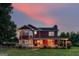 Charming two-story home featuring a inviting front porch, lush green lawn, and picturesque sunset backdrop at 68 Riveree Rd, Brooks, GA 30205