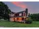 Charming red two-story home with a stone chimney and inviting front porch, set on a lush green lawn at 68 Riveree Rd, Brooks, GA 30205