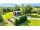 Stunning view of the red farmhouse with a backyard pool surrounded by green trees and open yard at 68 Riveree Rd, Brooks, GA 30205
