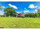 Charming red farmhouse featuring a covered front porch and lush green lawn extending to the treeline at 68 Riveree Rd, Brooks, GA 30205