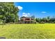 Beautiful two-story red farmhouse with a front porch set back on a large grassy lot at 68 Riveree Rd, Brooks, GA 30205