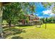Spacious front yard with a red two-story house and front porch shaded by a tree at 68 Riveree Rd, Brooks, GA 30205