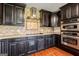 Modern kitchen featuring stainless steel appliances and dark cabinetry and backsplash at 68 Riveree Rd, Brooks, GA 30205