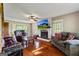 Comfortable living room features a cozy fireplace, large windows, ceiling fan, and hardwood floors at 68 Riveree Rd, Brooks, GA 30205