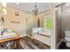 Elegant main bathroom featuring double sinks, a glass shower, and a soaking tub by a window at 68 Riveree Rd, Brooks, GA 30205