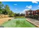 Backyard view of private pool with lush greenery and a charming red house in the background at 68 Riveree Rd, Brooks, GA 30205