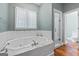 Bathroom featuring a white jacuzzi tub with marble trim and a glass door shower at 441 Crumbley Rd, Mcdonough, GA 30252