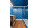 Stylish bathroom featuring unique wallpaper, wood floors, vanity, and glass shower with blue subway tile at 441 Crumbley Rd, Mcdonough, GA 30252