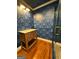 Stylish bathroom featuring a wooden vanity with modern fixtures, a glass-enclosed shower and blue patterned walls at 441 Crumbley Rd, Mcdonough, GA 30252