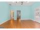 Empty bedroom featuring light blue walls, hardwood flooring and multiple doors at 441 Crumbley Rd, Mcdonough, GA 30252