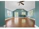 Bonus room showcases high ceilings, hardwood floors, windows, french doors to deck and teal-colored walls at 441 Crumbley Rd, Mcdonough, GA 30252