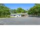 Exterior view of the house with a large parking area, mature trees and ample room for vehicles at 441 Crumbley Rd, Mcdonough, GA 30252