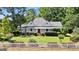 Charming home featuring a spacious porch, manicured lawn, and a classic white picket fence at 441 Crumbley Rd, Mcdonough, GA 30252