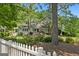 A home with a white picket fence and lush landscaping provides privacy and curb appeal at 441 Crumbley Rd, Mcdonough, GA 30252