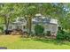 Picturesque home exterior with a wraparound porch, mature trees, and lush landscaping at 441 Crumbley Rd, Mcdonough, GA 30252