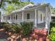 Inviting front porch with white columns, a cozy seating area, and lush landscaping around the brick steps at 441 Crumbley Rd, Mcdonough, GA 30252