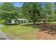 View of the grounds with a treehouse, a large barn, and a paved drive path at 441 Crumbley Rd, Mcdonough, GA 30252