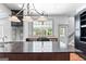 A gourmet kitchen features a dark island, apron sink, stainless appliances, and a view of the outdoor scenery at 441 Crumbley Rd, Mcdonough, GA 30252