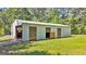 Outbuilding with multiple bays; one with a roll up door, surrounded by a lush green lawn at 441 Crumbley Rd, Mcdonough, GA 30252