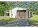 Outbuilding with a garage door in a lush, green, wooded area at 441 Crumbley Rd, Mcdonough, GA 30252
