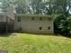 Rear exterior view of brick home with large windows, a deck, and grassy yard at 6236 Shallow Creek Ln, Douglasville, GA 30135