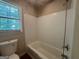 Bathroom featuring tiled shower-tub, white fixtures and window at 6236 Shallow Creek Ln, Douglasville, GA 30135