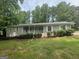 Charming single-story home features a welcoming front porch, fresh lawn and tidy landscaping at 6236 Shallow Creek Ln, Douglasville, GA 30135