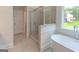 Modern bathroom featuring a shower, a soaking tub and a large window with natural light at 3292 Mill Forest Sw Dr, Conyers, GA 30094