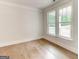 Cozy bedroom with hardwood floors, base molding, and natural light streaming through windows at 3292 Mill Forest Sw Dr, Conyers, GA 30094