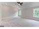 Spacious bedroom with neutral carpet, ceiling fan, and ample natural light from two windows at 3292 Mill Forest Sw Dr, Conyers, GA 30094
